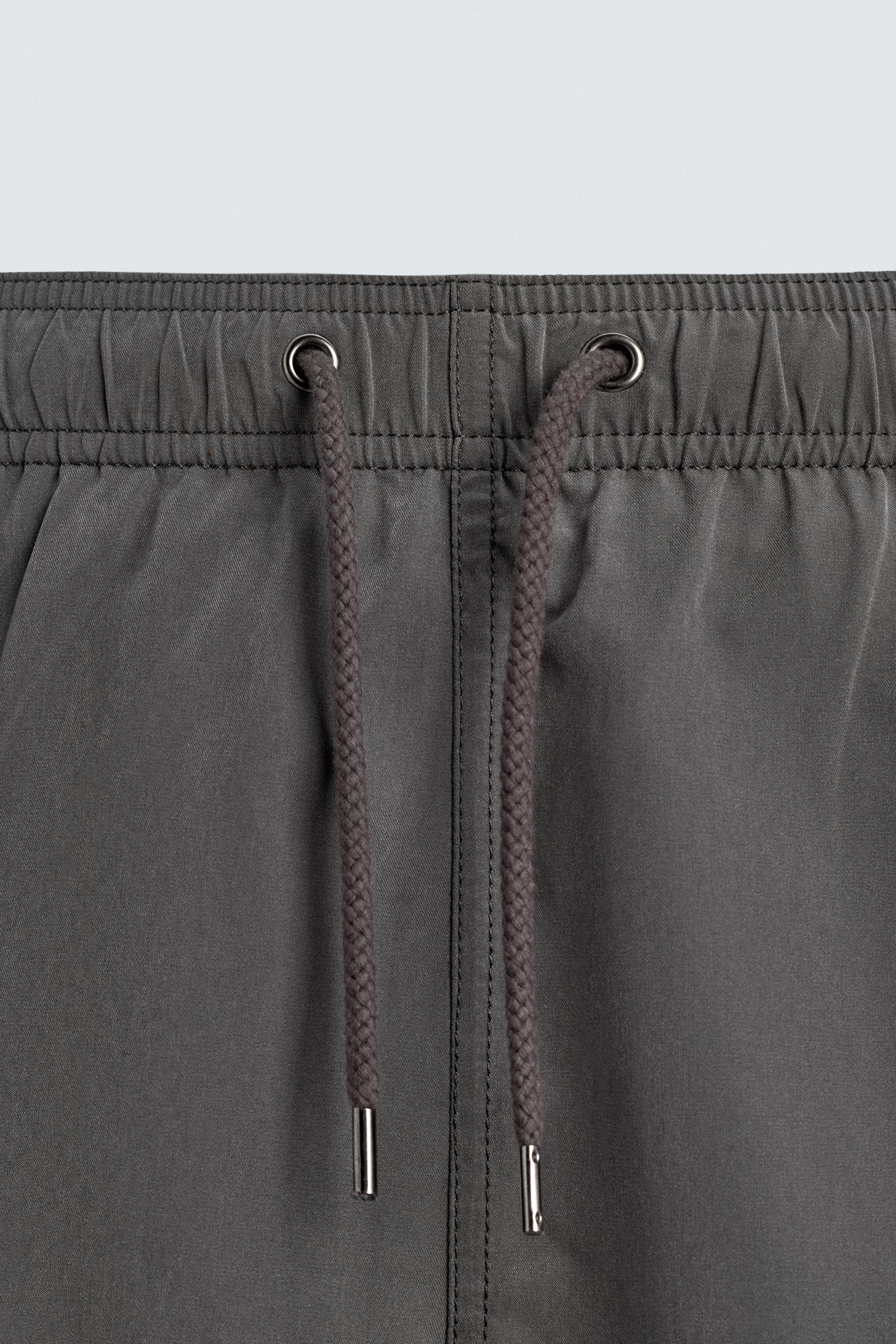 MAILLOT DE BAIN MI-LONG À ŒILLETS MÉTALLIQUES